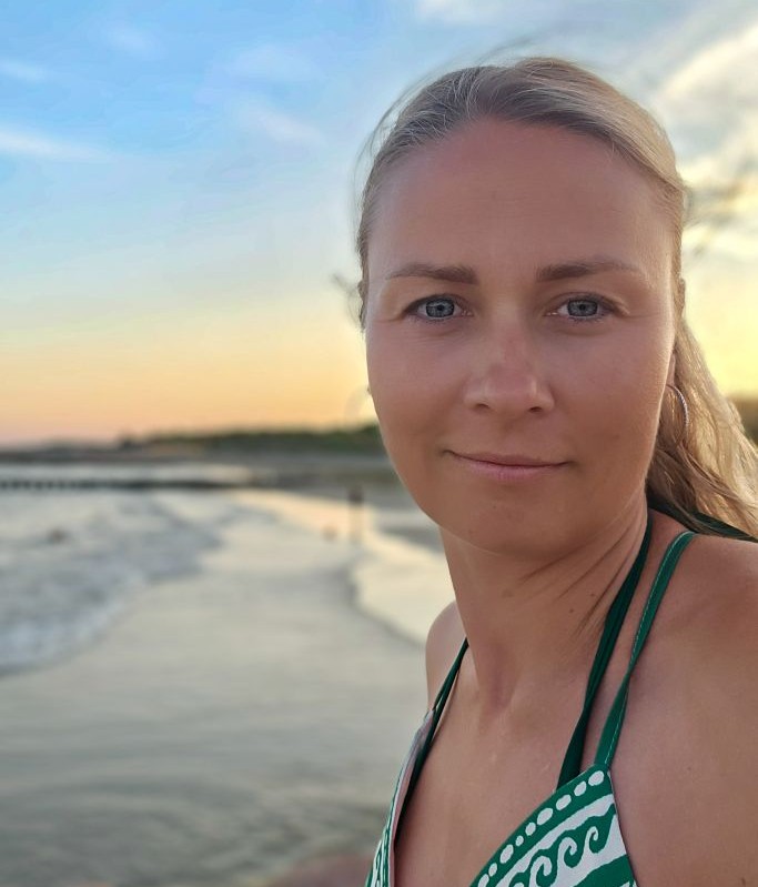 Portrait einer Frau mit ruhigem, freundlichem Ausdruck am Strand bei Sonnenuntergang – Kosmische Farbberatung