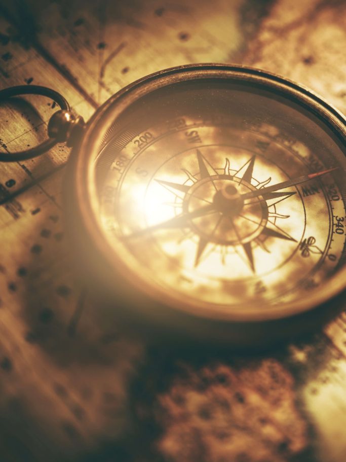 Antiker Kompass auf einer alten Weltkarte, in warmem Licht, symbolisch für Orientierung und Wegfindung im Solar Return Reading