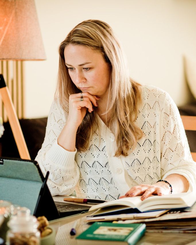 Maria Koch arbeitet konzentriert mit Notizen und Tablet in ruhiger Umgebung