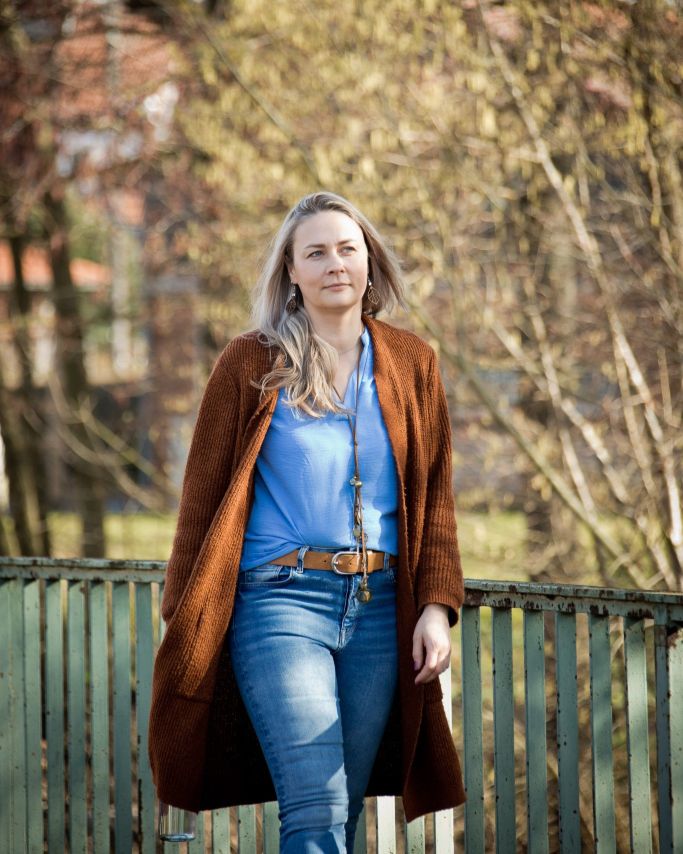 Maria Koch geht entspannt im Freien und verkörpert Klarheit, Selbstvertrauen und Verbindung zur Natur